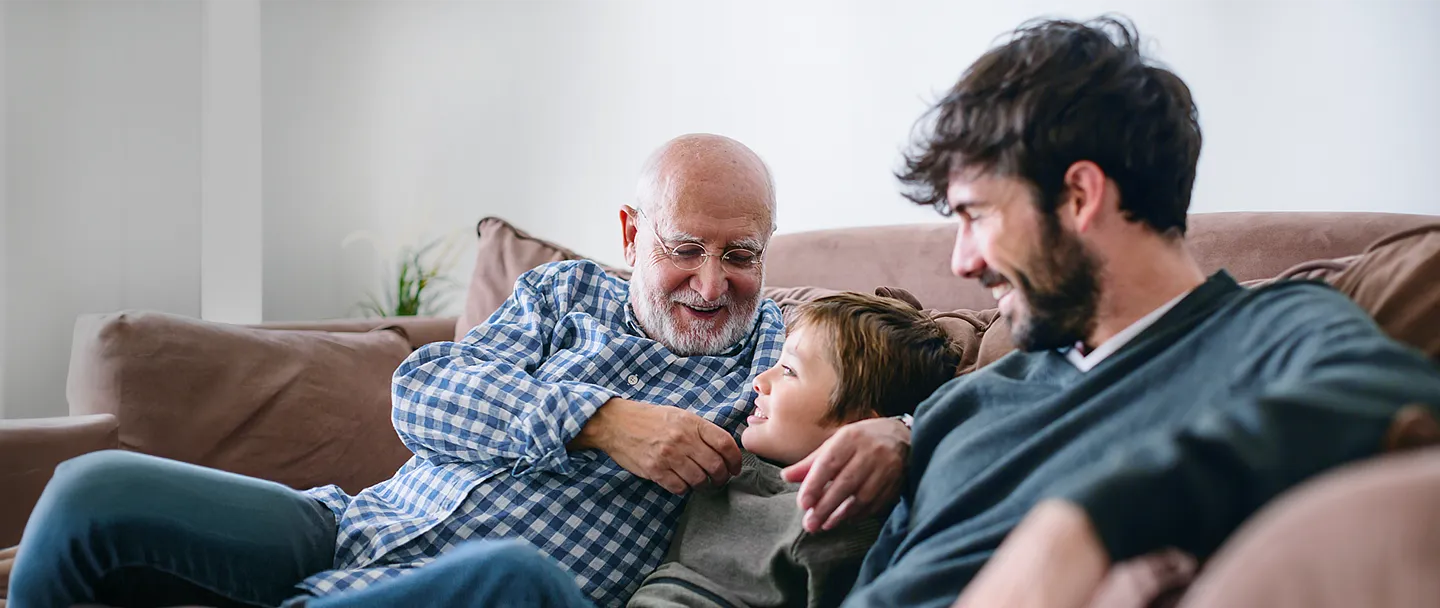 Großvater, Vater und Sohn zu Hause auf dem Sofa.